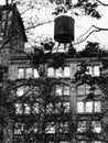 Black and white photo of building with water tank tower and park trees Royalty Free Stock Photo