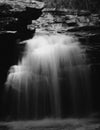 Grayscale photography of a strong running waterfall in a forest