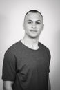Grayscale portrait of a handsome multi-racial man with a buzz cut standing against the wall Royalty Free Stock Photo
