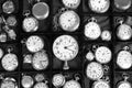 Grayscale selective focus shot of clocks on the shelves