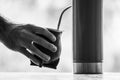 Grayscale selective focus shot of a hand holding calabash mate cup with straw