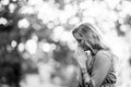 Grayscale, selective shot of a blonde female praying - religion concept