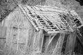 Grayscale shot of an abandoned stable building in a field Royalty Free Stock Photo