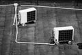 Grayscale shot of air conditioner units on a building rooftop