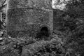 Grayscale shot of an arch in a stone tower