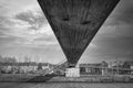 Grayscale shot of a bridge over the river under the cloudy sky Royalty Free Stock Photo