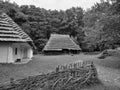 Grayscale shot of cabins surrounded by a forest in Old Village, Poland Royalty Free Stock Photo