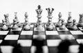 Grayscale shot of a chessboard with a full set of chess pieces arranged on the board. Royalty Free Stock Photo