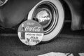 Grayscale shot of Coca-Cola check your tire sign with tire