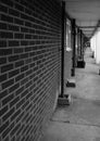 Grayscale shot of the Council housing estate corridor with converging lines brickwork