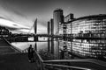 Grayscale shot of a couple enjoying the view of the Quays in Salford