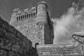 Grayscale shot of a detail of a medieval tower of homage