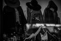 Grayscale shot of displayed mannequins wearing casual clothes and hats