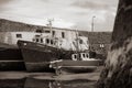 Grayscale shot of the docked fishing boats in Balbriggan harbor at low tide