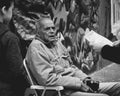 Grayscale shot of an elderly male sitting on the chair on the streets of Sao Paulo, Brazil