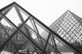 Grayscale shot of the exterior of the Louvre Pyramid in Paris, France