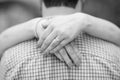 Grayscale shot of female hands hugging her husband