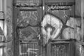 Grayscale shot of graffiti on wooden entrance doors