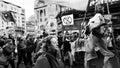 Grayscale shot of a group of angry COP26 protestors marching in the streets of Glasgow, Scotland