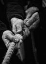 Grayscale shot of hands pulling a rope while playing Tug of war - concept of poverty Royalty Free Stock Photo