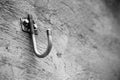 Grayscale shot of a hook attached to a concrete wall