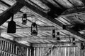 Grayscale shot of lamps hanging from a wooden ceiling