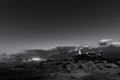 Grayscale shot of a lighthouse on top of the mountain Royalty Free Stock Photo