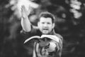 Grayscale shot of a male holding the Holy Bible and preaching it with a lot of enthusiasm