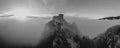 Grayscale shot of the mysterious Srebrenik fortress in fog, picturesque cloudscape in the background