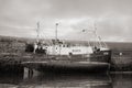 Grayscale shot of an old fishing boat docked at Balbriggan harbor at low tide