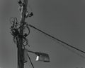 Grayscale shot of an old wooden electric pole with wires and a street lamp Royalty Free Stock Photo