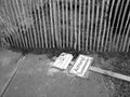 Grayscale shot overturned warning sign in front of an old wooden fence in Offenbach, Germany