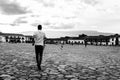 Grayscale shot of people in a town square on a cloudy day