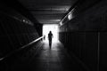 Grayscale shot of a person with exiting a subway station, their journey ahead of them