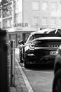 Grayscale shot of a Porsche car parked on the street.