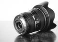 Grayscale shot of a professional DSLR camera lens on the table Royalty Free Stock Photo