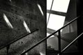 Grayscale shot of the railing of a staircase next to a stone wall - unknown future concept