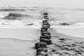 Grayscale shot of rocky stepstones from a seashore into the water in Cadzan Bad, New Zealand Royalty Free Stock Photo