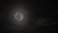 Grayscale shot of the shiny full moon on a cloudy sky at night - perfect for wallpaper