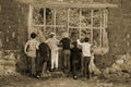 Grayscale shot of six best friends looking through an old window