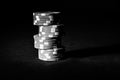 Grayscale shot of a stack of poker chips in the dark background with a copy space Royalty Free Stock Photo