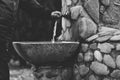 Grayscale shot of a stone sink in a stone wall