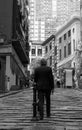Grayscale shot of a ,am strolling up a narrow city alleyway