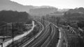 Grayscale shot of train tracks leading into the fog Royalty Free Stock Photo