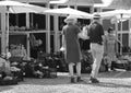 Grayscale shot of two people walking at a local market in Ikast, Denmark
