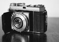 Grayscale shot of a vintage Kodak film camera on the table