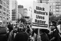 Grayscale shot of a woman holding a Black Lives Matter banner at a protest at Union Square, New York