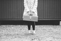 Grayscale shot of a woman holding a vintage suitcase Royalty Free Stock Photo