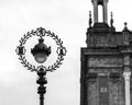 Grayscale of a single lamp post, with a building in the background Royalty Free Stock Photo