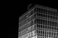 Grayscale of a tall radio station building illuminated at night